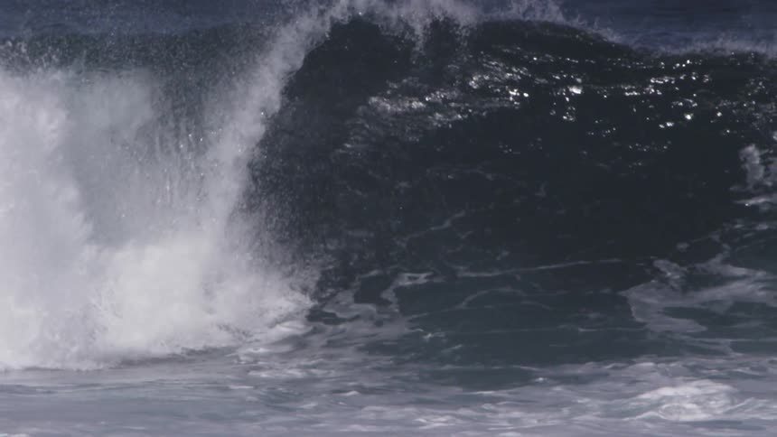 A man is riding a large wave on his board