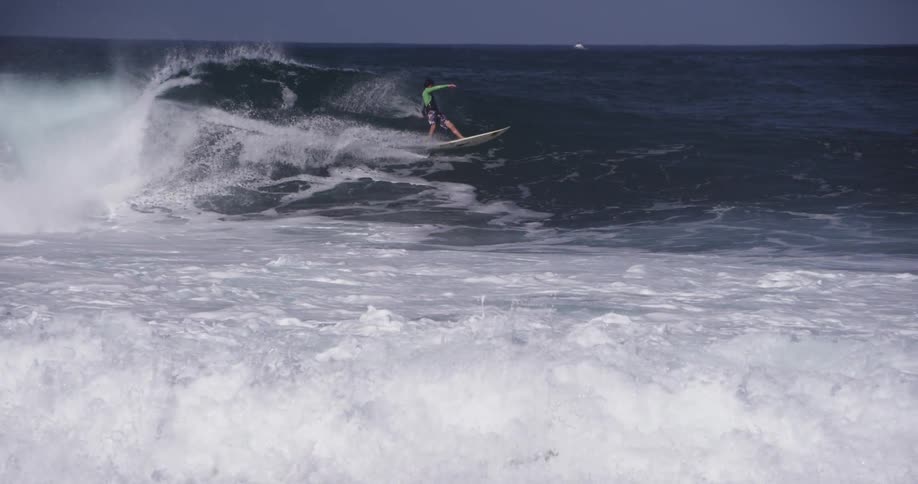 Person surfs large ocean waves