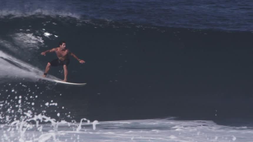 A surfer is riding a wave on a sunny day