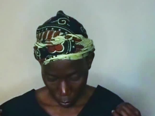 Portrait of a person with a green and black cloth on their head