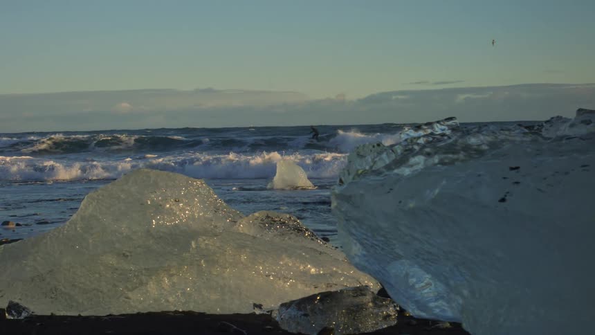 In an arctic environment the shot pans through an iceberg to see a surfer carving the waves