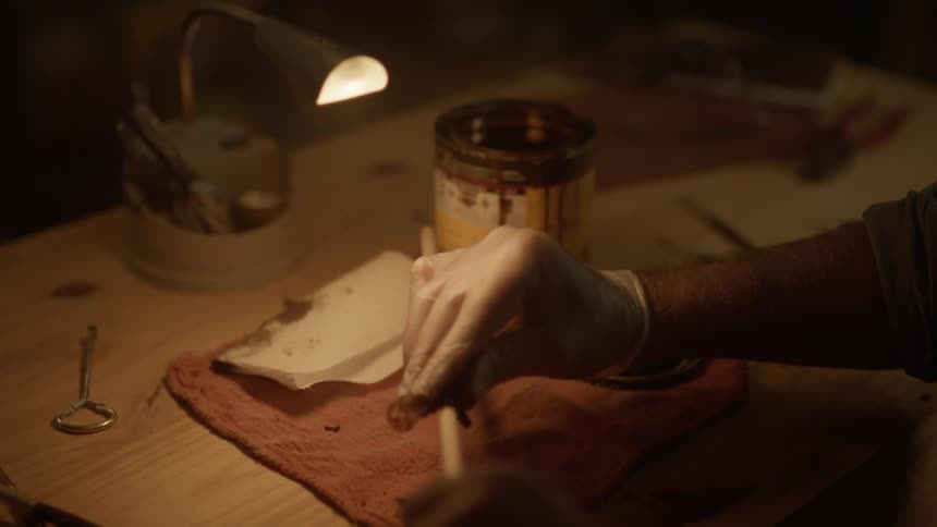 A man rubs wood finish on the stick
