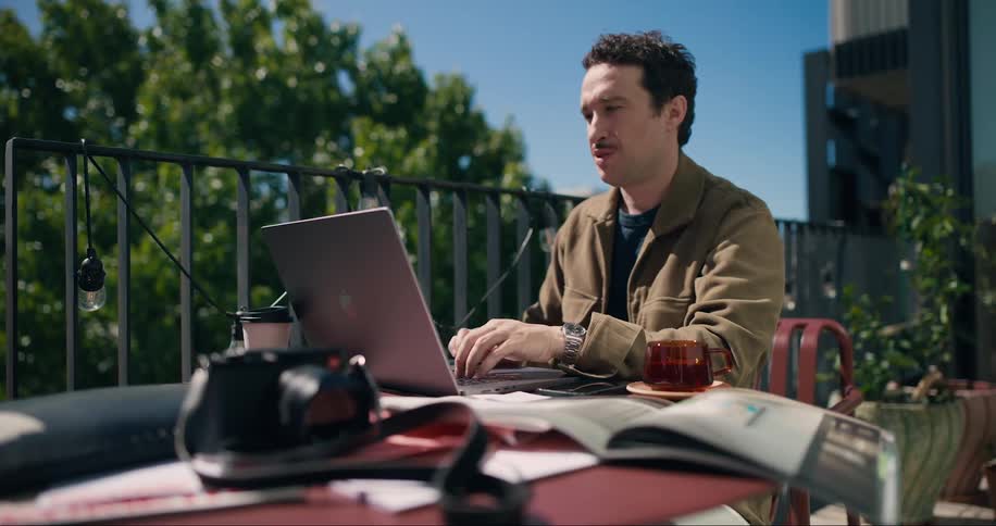Man sitting in a chair in front of a laptop