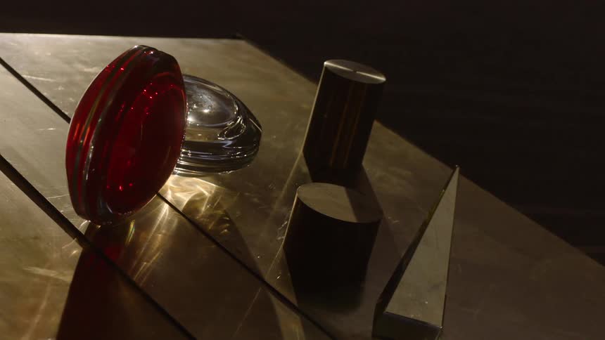 Glass and metal objects on a table with sunlight reflecting off them