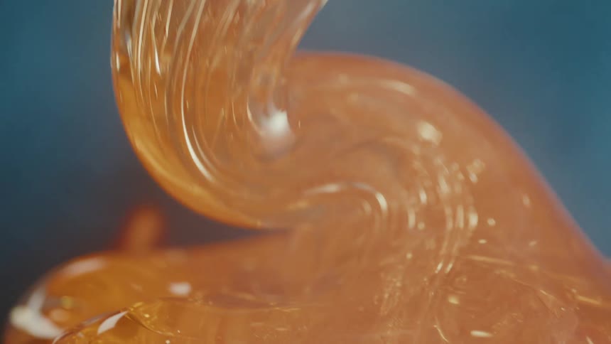 A glass element that is orange in color and is melting downwards