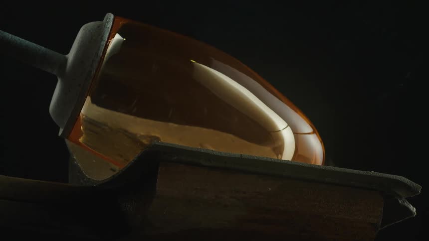 Smoke rises from a piece of glass being shaped