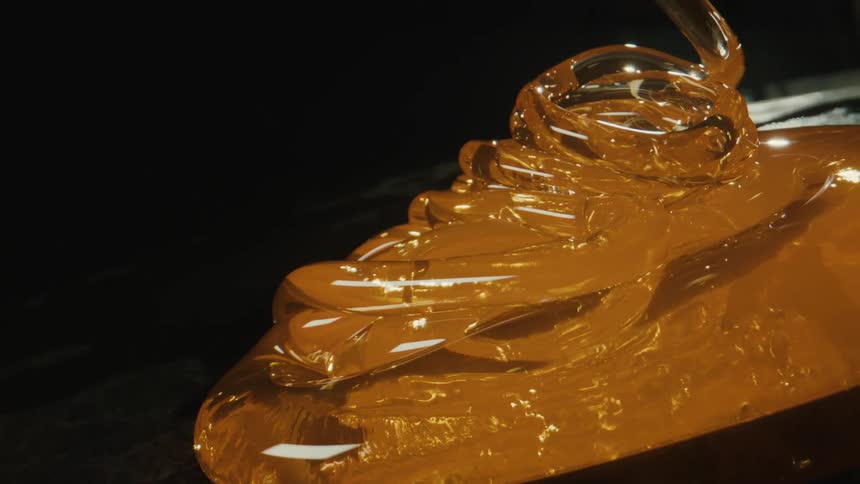 Glass in a heated state being poured onto a dark surface