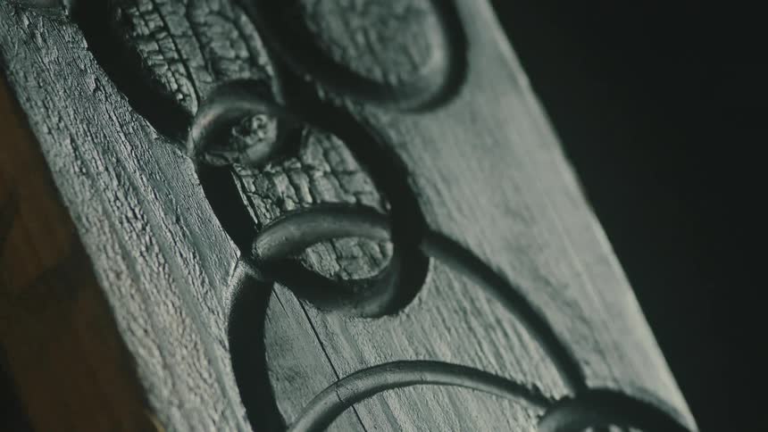Close up of a piece of wood with carved metal rings