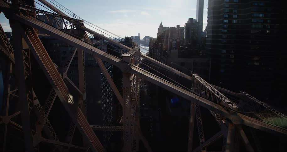 Metal bridge in the foreground and a seaside metropolis in the background