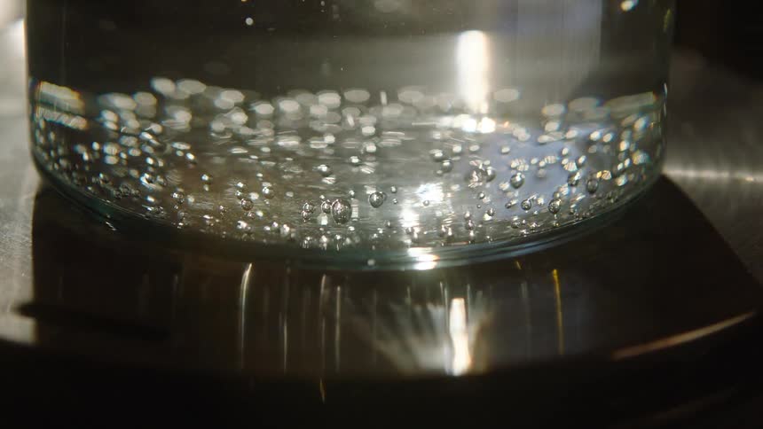 Close up of a glass with air bubbles on top of a surface