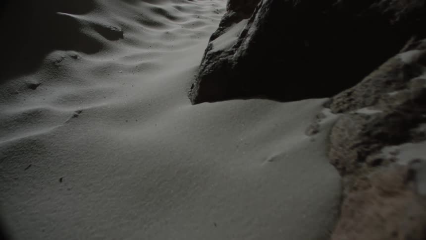 Rocks in the middle of a sandy path in a dark place