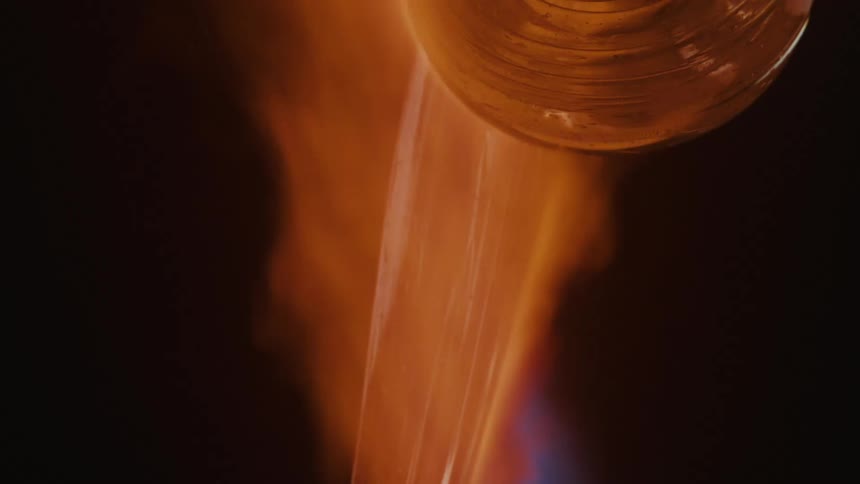 Fire burns orange then blue during a glass making project