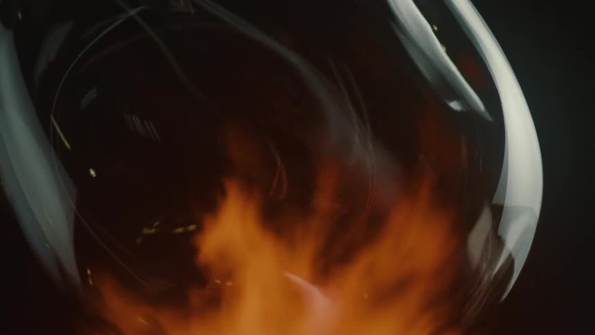 A glass vase is being heated by an open red flame capturing the glassblowing process