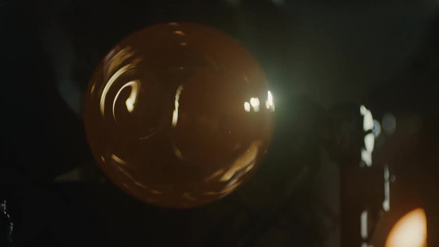 Closeup of an amber forged glass in a dark environment