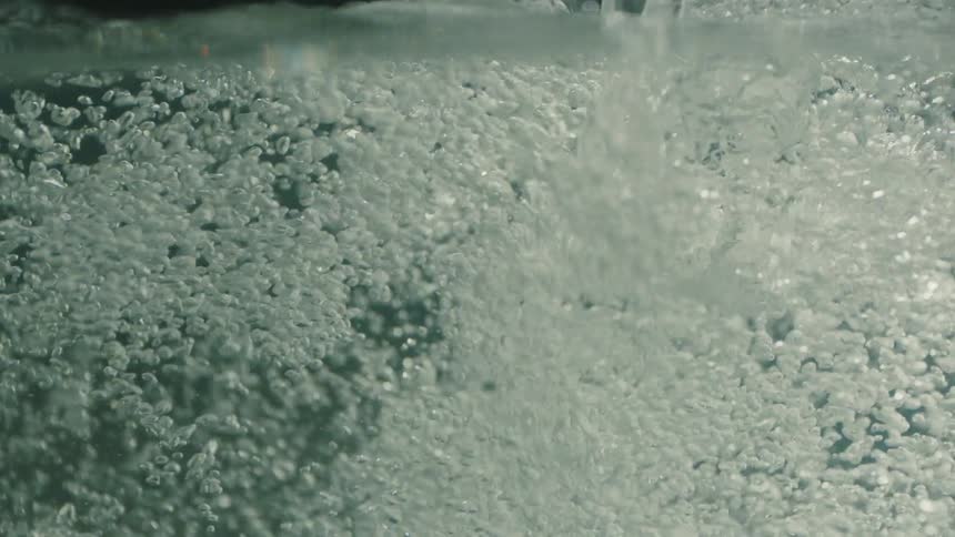 Water pours and bubbles fill the area underwater