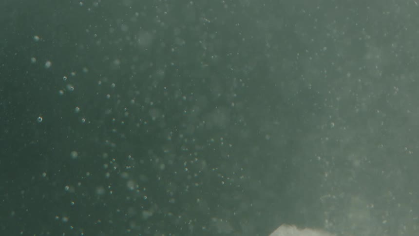 Ice sinks in the water making bubbles float up