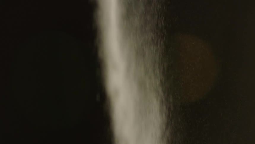 Close up of a jet of sand in free fall