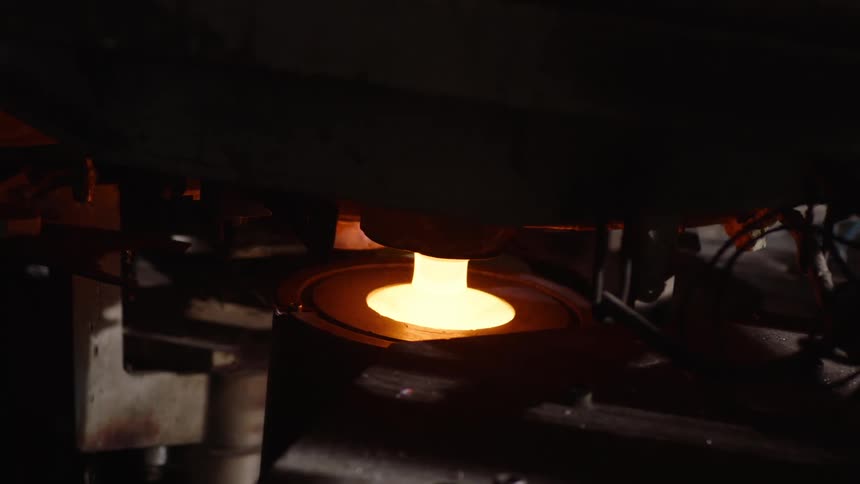 Incandescent part being molded by an industrial press
