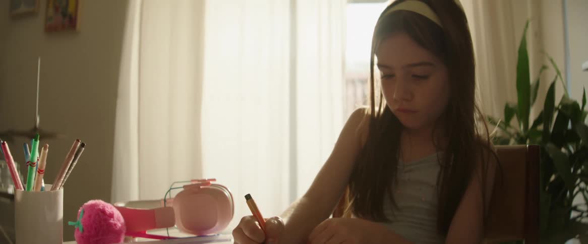 The face lingers girl who is sitting and is writing using a pen