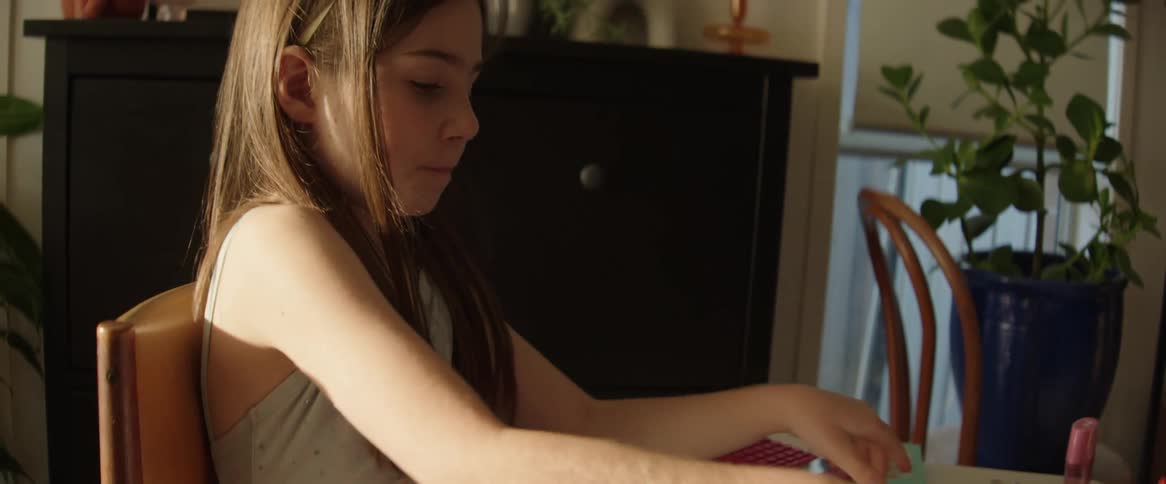A girl puts her marker away after drawing