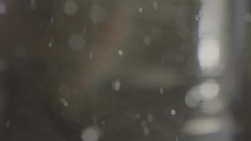 Closeup of air bubbles rising in a clear liquid within a glass