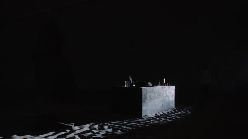 Shade moves across the table in the room full of sand