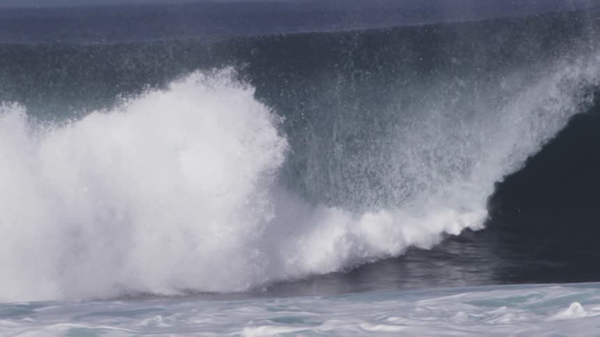 An ocean wave crashes down
