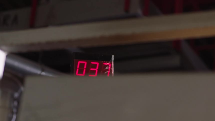 A digital timer in a warehouse or factory counts from 35 to 38 and back to zero