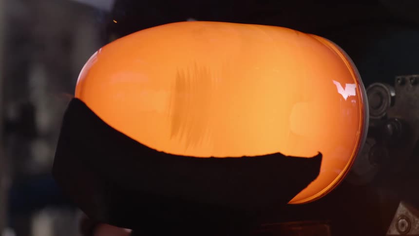 The hot glass is glowing as it spins