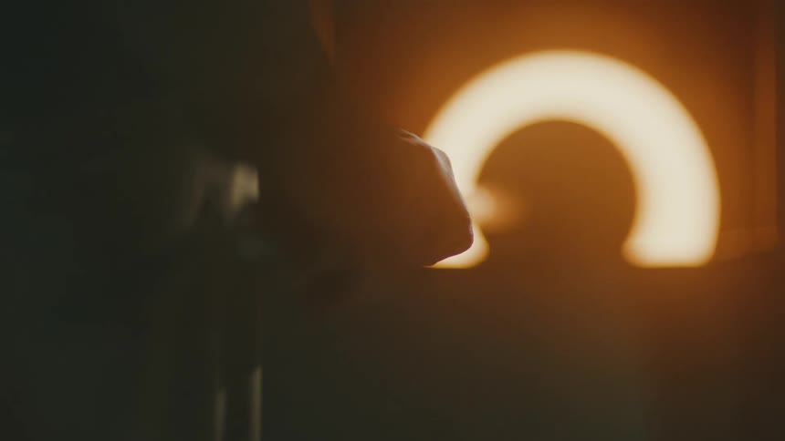 Silhouette of a persons hand holding a tool and forging glass