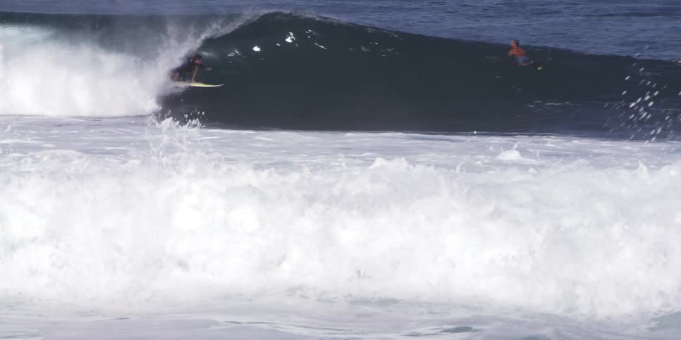 Person surfs ocean waves and gets engulfed by the wave