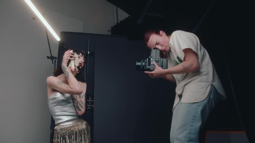 Photographer takes video of a model holding a package during a photo shoot