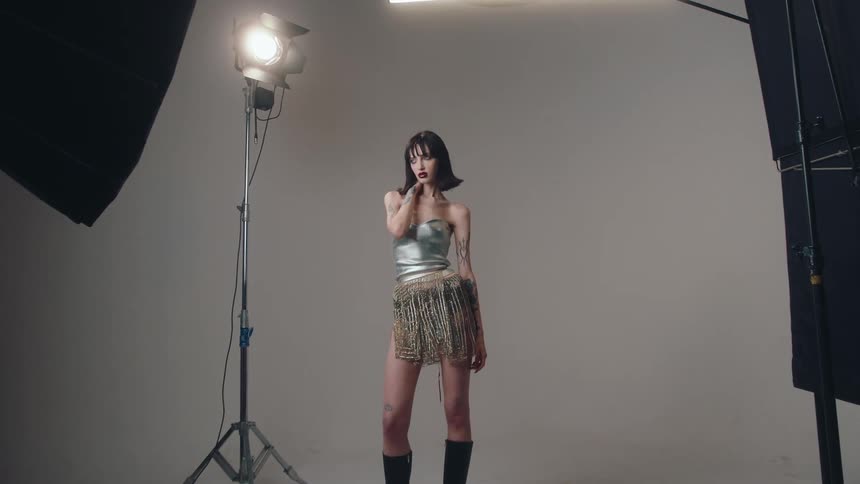 A young woman modeling a modern outfit on a photographic studio