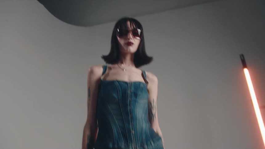 Woman in sunglasses modeling in a studio