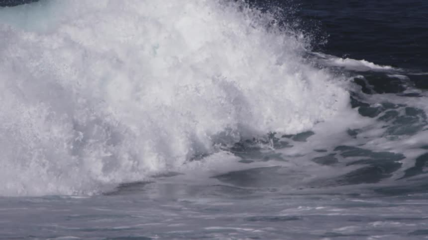 A wave curls and crests as it crashes back into the ocean