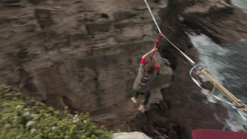 Man balancing on a tightrope, falling and balancing again