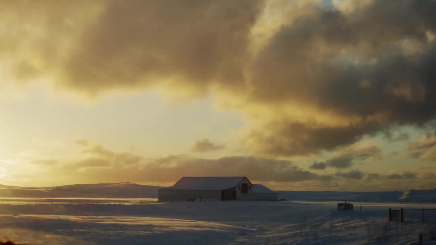 Rural house in a field covered by snow