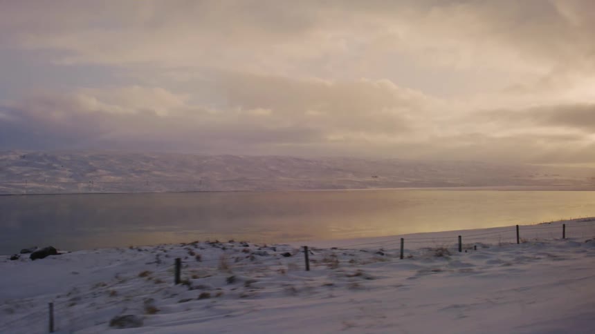 Snowy seaside area with mountains in the background