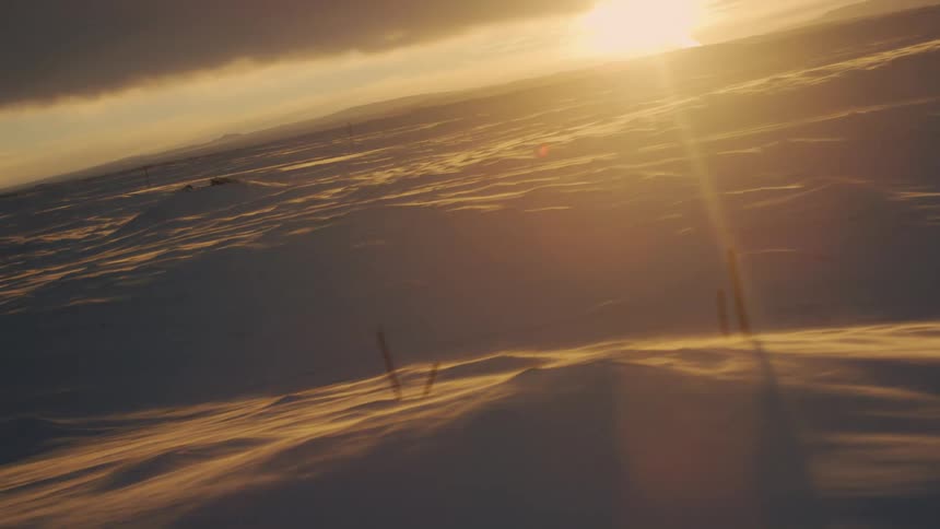 The sun is rising on the snowy landscape covered with heavy clouds