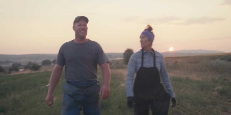 Woman and a man walking in an agricultural field one morning