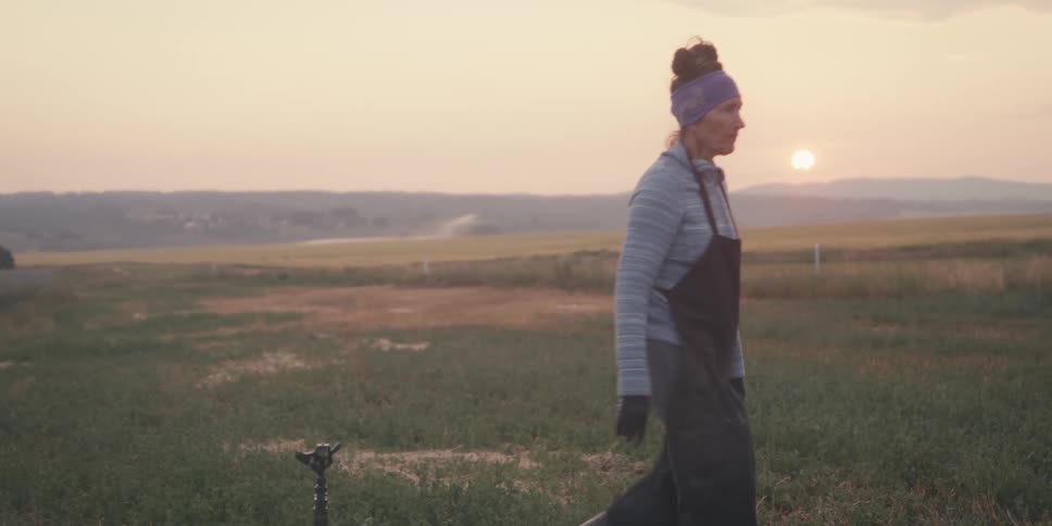 Woman in a black apron walking in a rural area