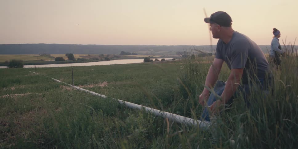 Man holding the lever of an irrigation system in a field