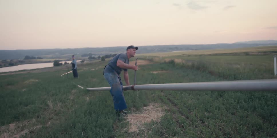Man picking up a metal pipe in a corner