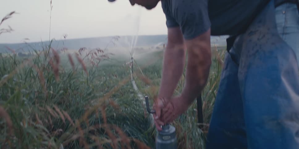 A man turns on the water to irrigate his farm