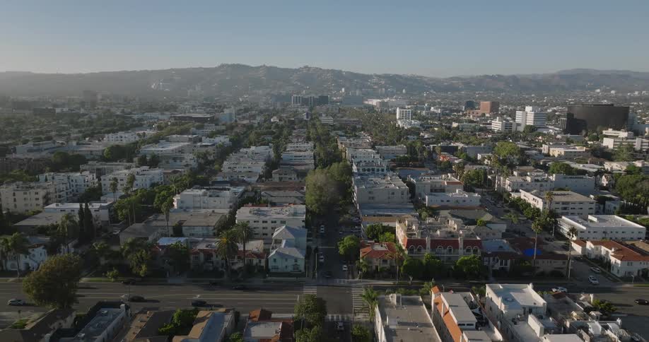 Panorama of an urban city with intersections with vegetation and mountains in the background