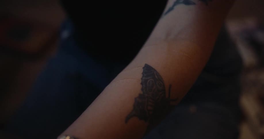 A person has a butterfly tattoo on their arm
