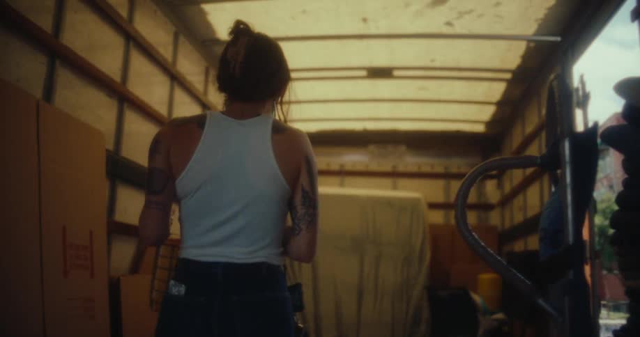 A woman carries books out of the trailer