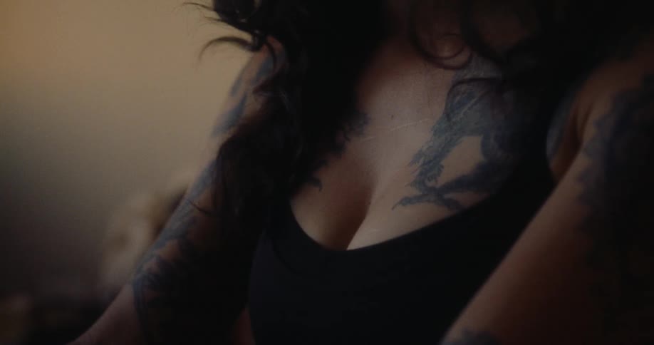 A woman has large tattoos on her arms and shoulders