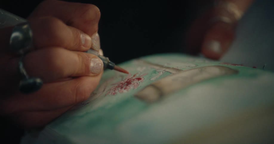 Close up of a hand with a paintbrush painting