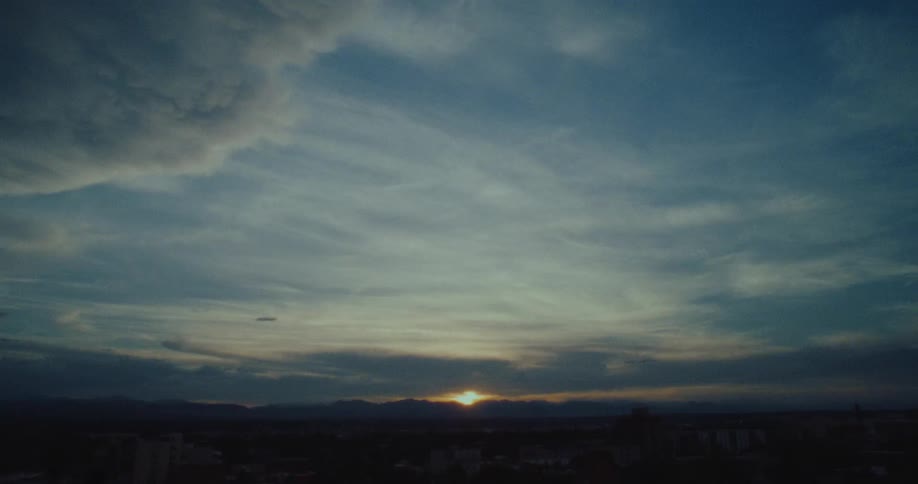 Natural landscape with silhouettes of mountains and the sun on the horizon